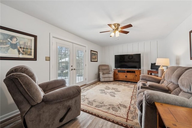 living room featuring ceiling fan, baseboards, wood finished floors, and french doors