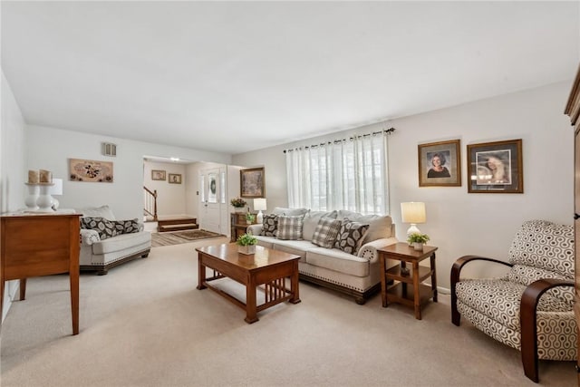 living area featuring visible vents, light carpet, and stairway