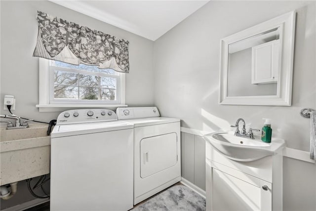 laundry room with laundry area, a sink, and separate washer and dryer