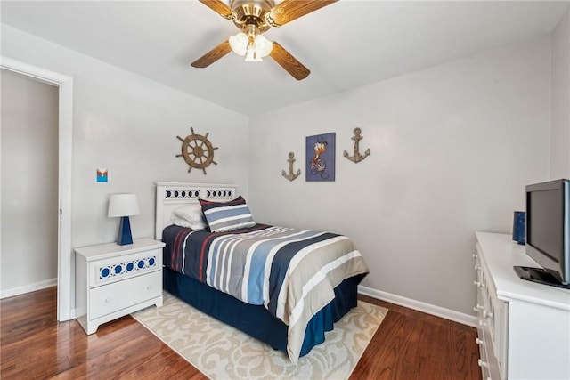 bedroom with ceiling fan, wood finished floors, and baseboards