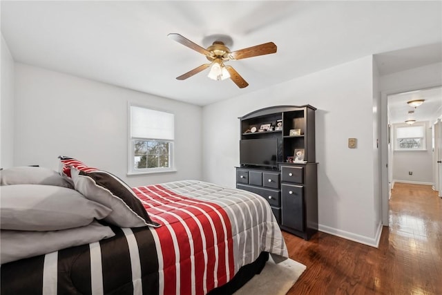 bedroom with ceiling fan, baseboards, and dark wood finished floors