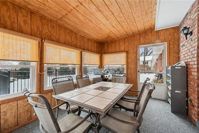 dining area featuring wood ceiling, wood walls, and carpet