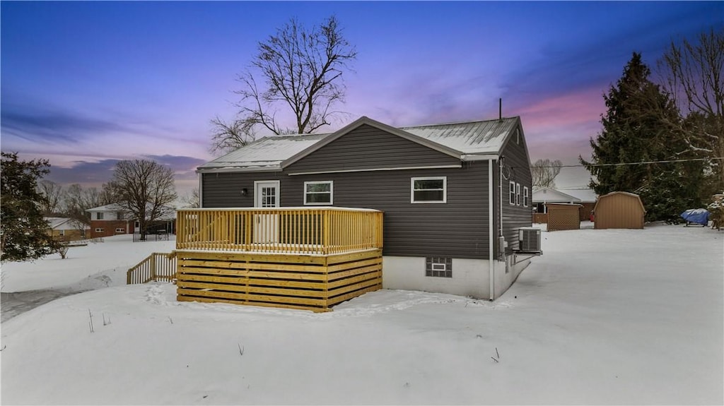 view of front of home featuring a shed, an outbuilding, central AC, and a wooden deck