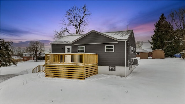 view of front of home featuring a shed, an outbuilding, central AC, and a wooden deck