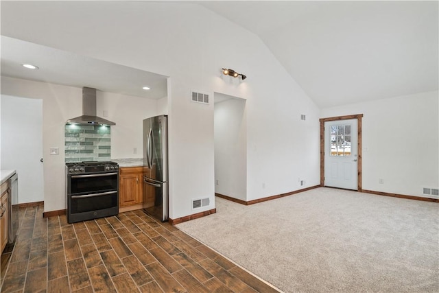 kitchen featuring appliances with stainless steel finishes, light countertops, visible vents, and wall chimney exhaust hood