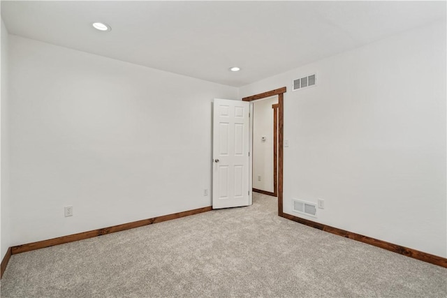 empty room with light colored carpet, visible vents, baseboards, and recessed lighting