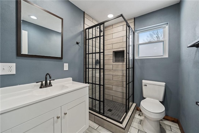 full bath featuring toilet, a shower stall, vanity, and baseboards