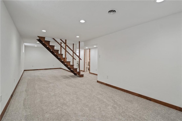 unfurnished room with light carpet, baseboards, visible vents, stairway, and recessed lighting