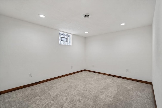 carpeted spare room featuring recessed lighting, visible vents, and baseboards