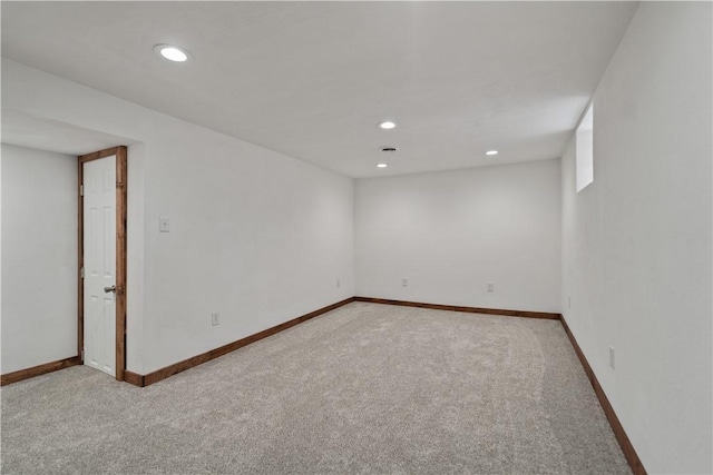 basement featuring baseboards, recessed lighting, and light colored carpet