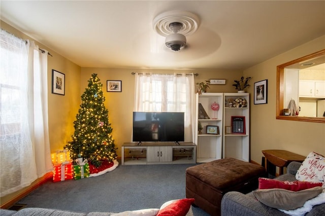 living room featuring carpet and a ceiling fan