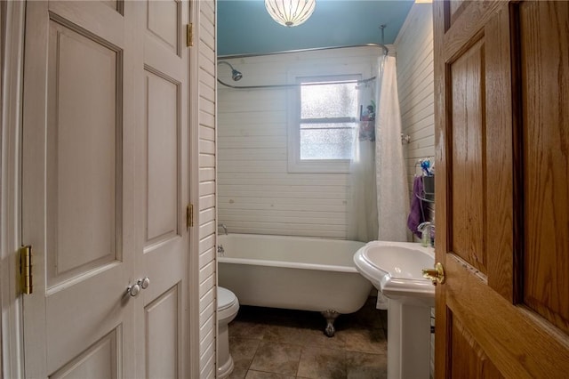 full bath with washtub / shower combination, tile patterned flooring, a sink, and toilet