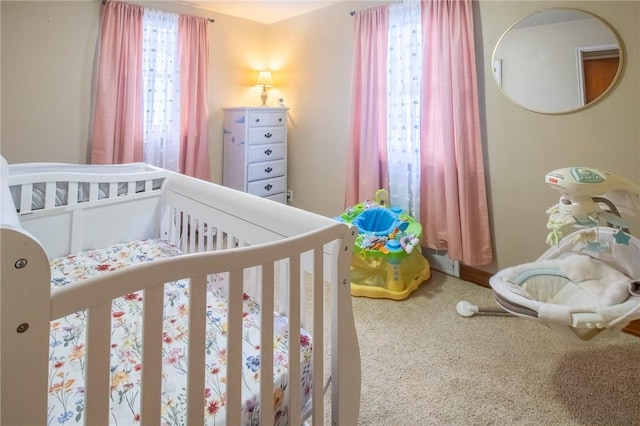 carpeted bedroom with a nursery area