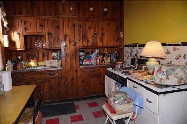 kitchen featuring light countertops, light floors, and white gas range oven