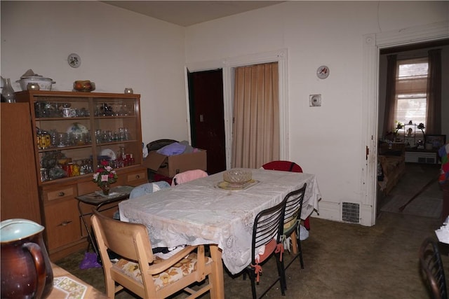 dining area with visible vents and dark carpet