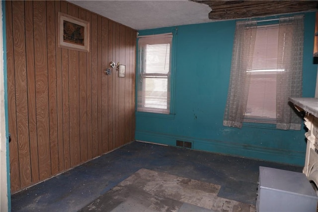 empty room featuring wooden walls and visible vents