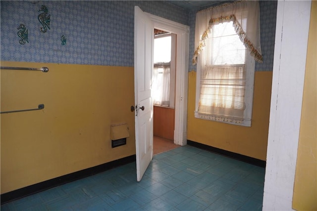 doorway featuring wallpapered walls, baseboards, and tile patterned floors