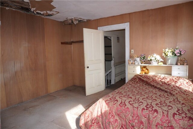 bedroom featuring wood walls