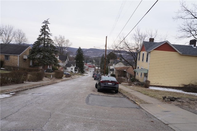 view of road with sidewalks, a residential view, and curbs