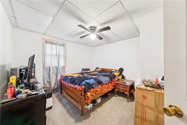 carpeted bedroom with a paneled ceiling and a ceiling fan