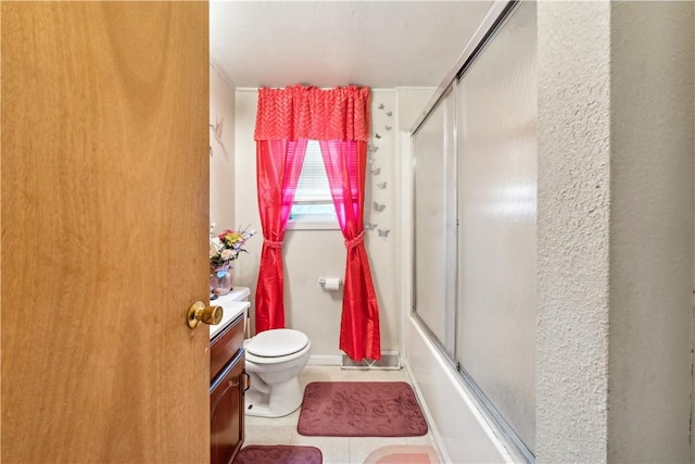 bathroom with toilet, tile patterned floors, combined bath / shower with glass door, and vanity