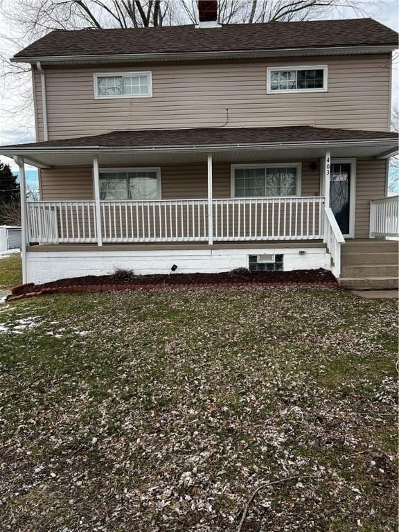 view of front of home featuring a porch, a chimney, and a front yard