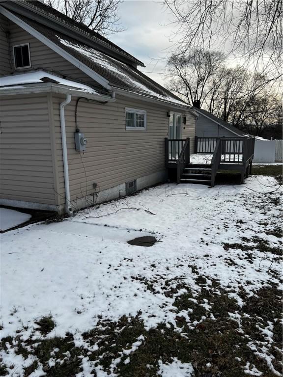 view of snowy exterior with a wooden deck