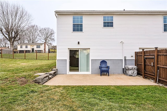 rear view of property featuring a lawn, a patio area, and fence