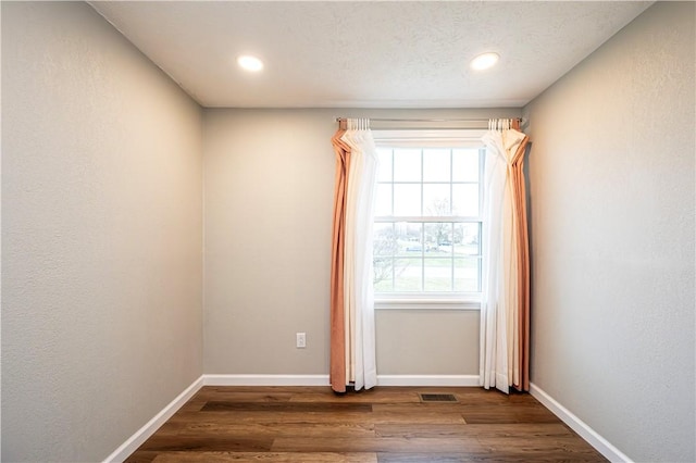 unfurnished room with dark wood-type flooring, recessed lighting, visible vents, and baseboards