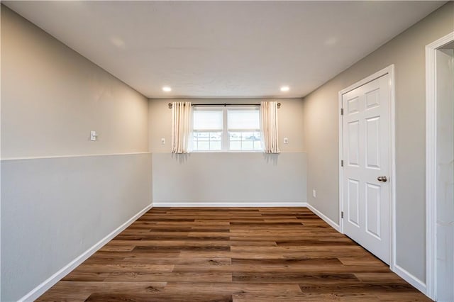 empty room featuring recessed lighting, dark wood finished floors, and baseboards