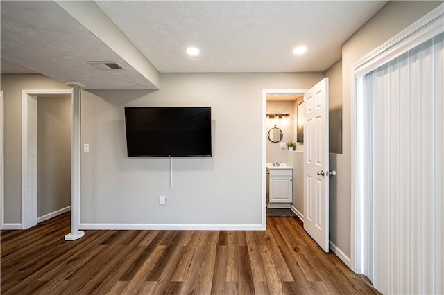 unfurnished living room featuring visible vents, baseboards, and dark wood finished floors