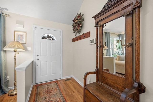 foyer entrance with wood finished floors and baseboards