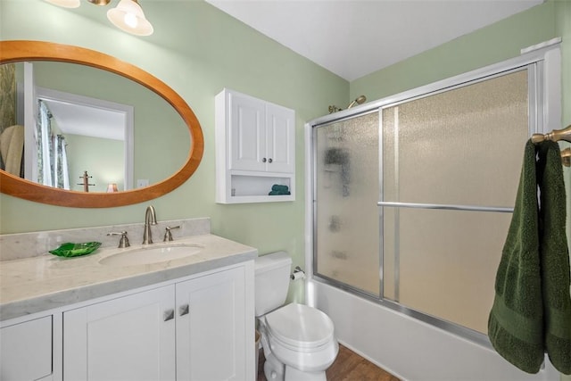 full bathroom featuring shower / bath combination with glass door, vanity, and toilet