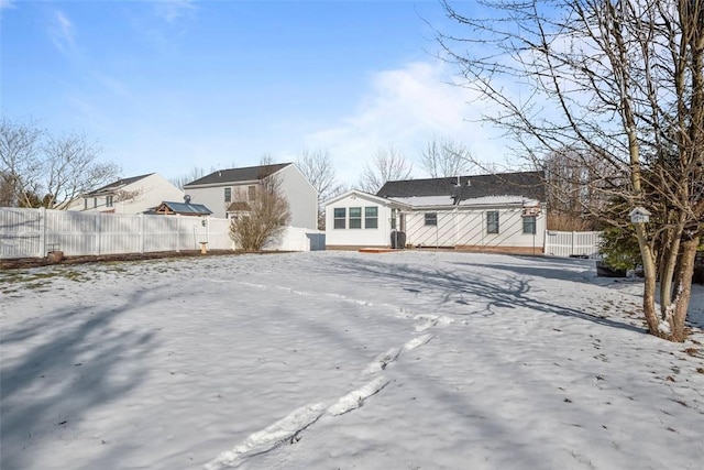 snow covered house with fence