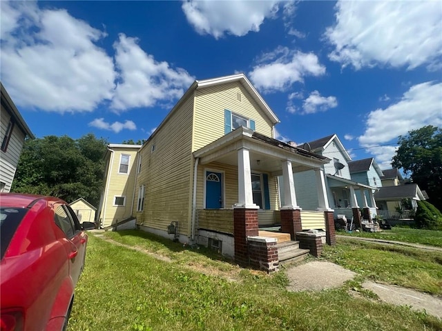 view of front of home featuring covered porch and a front yard