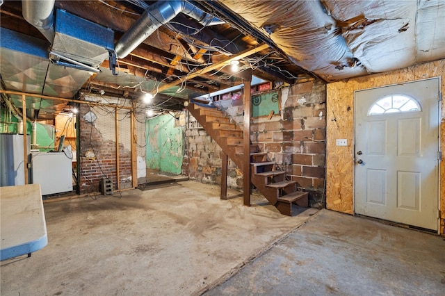 unfinished basement featuring washer / dryer and stairway