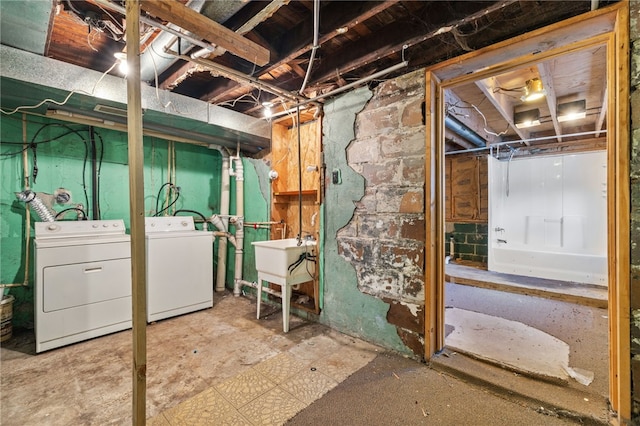 unfinished basement featuring washer and clothes dryer and a sink