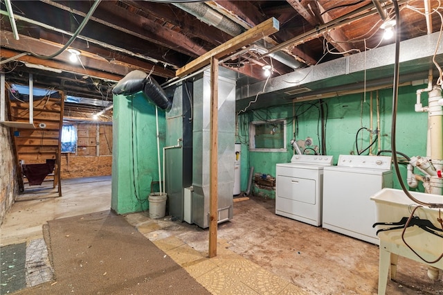 below grade area featuring electric water heater, independent washer and dryer, and heating unit