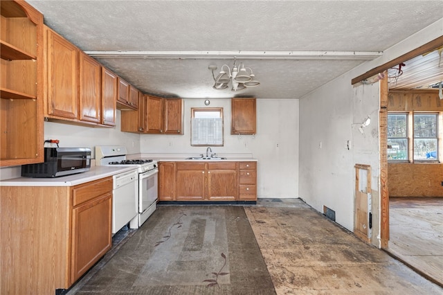 kitchen with plenty of natural light, white appliances, light countertops, and a sink