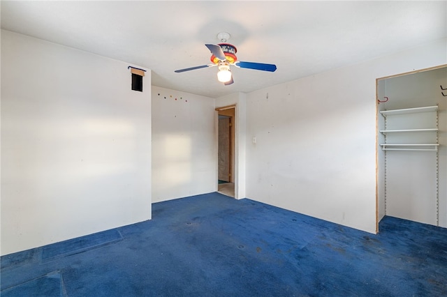 unfurnished bedroom with a ceiling fan, dark colored carpet, and a closet