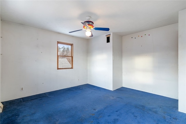 empty room with ceiling fan and dark carpet