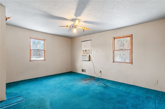 carpeted spare room with ceiling fan, a textured ceiling, and cooling unit