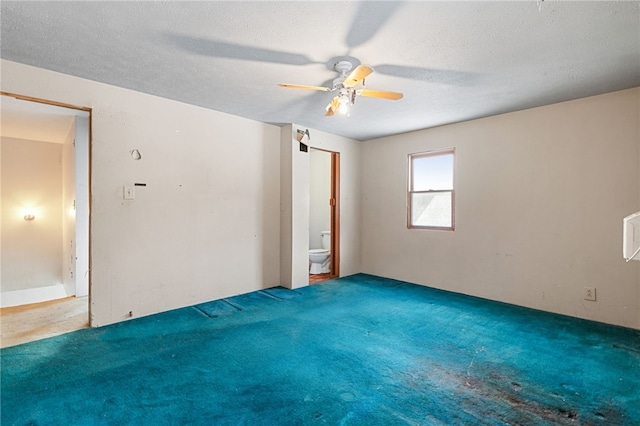 spare room featuring carpet floors, a ceiling fan, and a textured ceiling