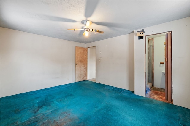 unfurnished bedroom with a ceiling fan, carpet flooring, connected bathroom, and a textured ceiling