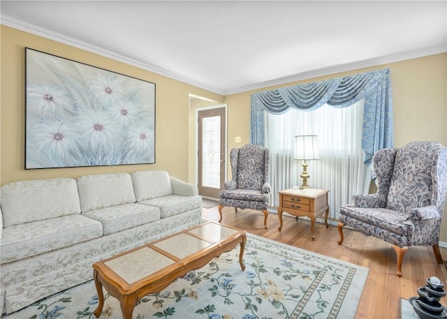 living area featuring ornamental molding and wood finished floors