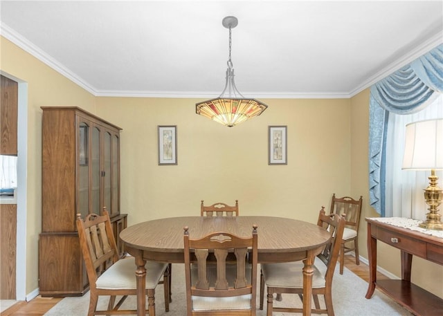 dining room with light wood-style flooring, baseboards, and crown molding