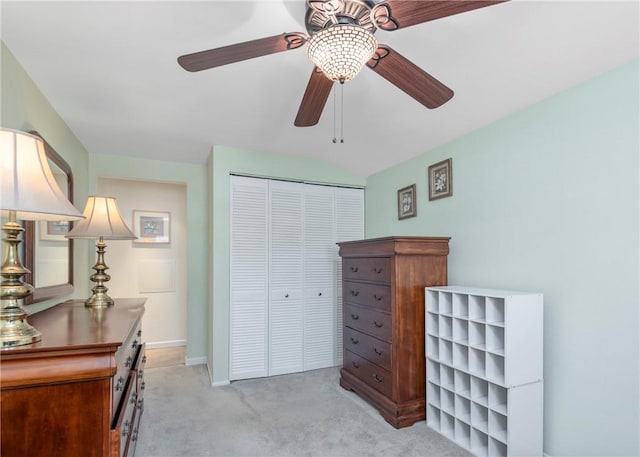 bedroom featuring baseboards, a ceiling fan, a closet, and light colored carpet