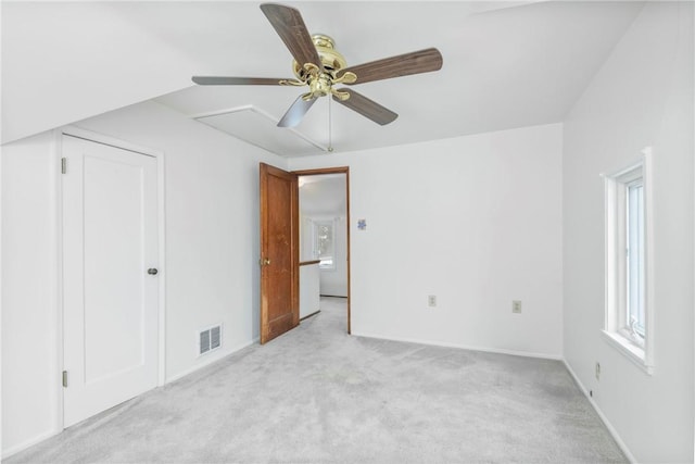 unfurnished bedroom with a ceiling fan, visible vents, light carpet, and baseboards