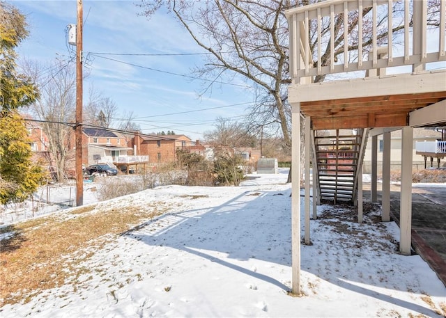 yard layered in snow with stairs and a residential view