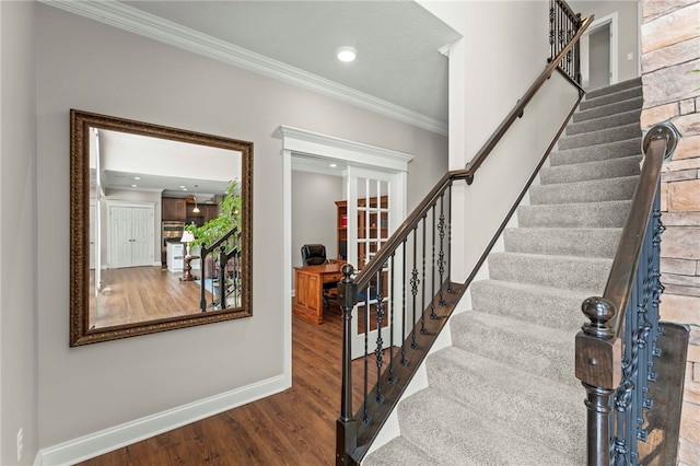 stairs with baseboards, recessed lighting, wood finished floors, and crown molding